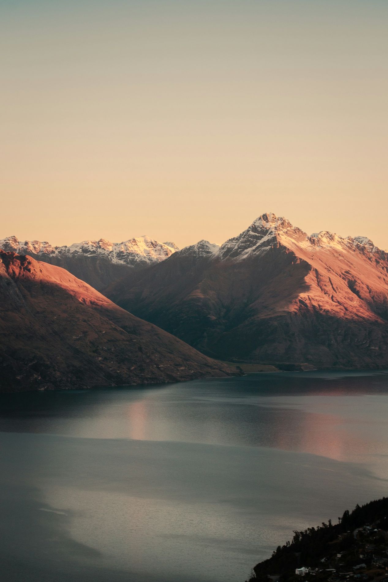 The Remarkables in snow, lit pink at last light above Lake Wakatipu