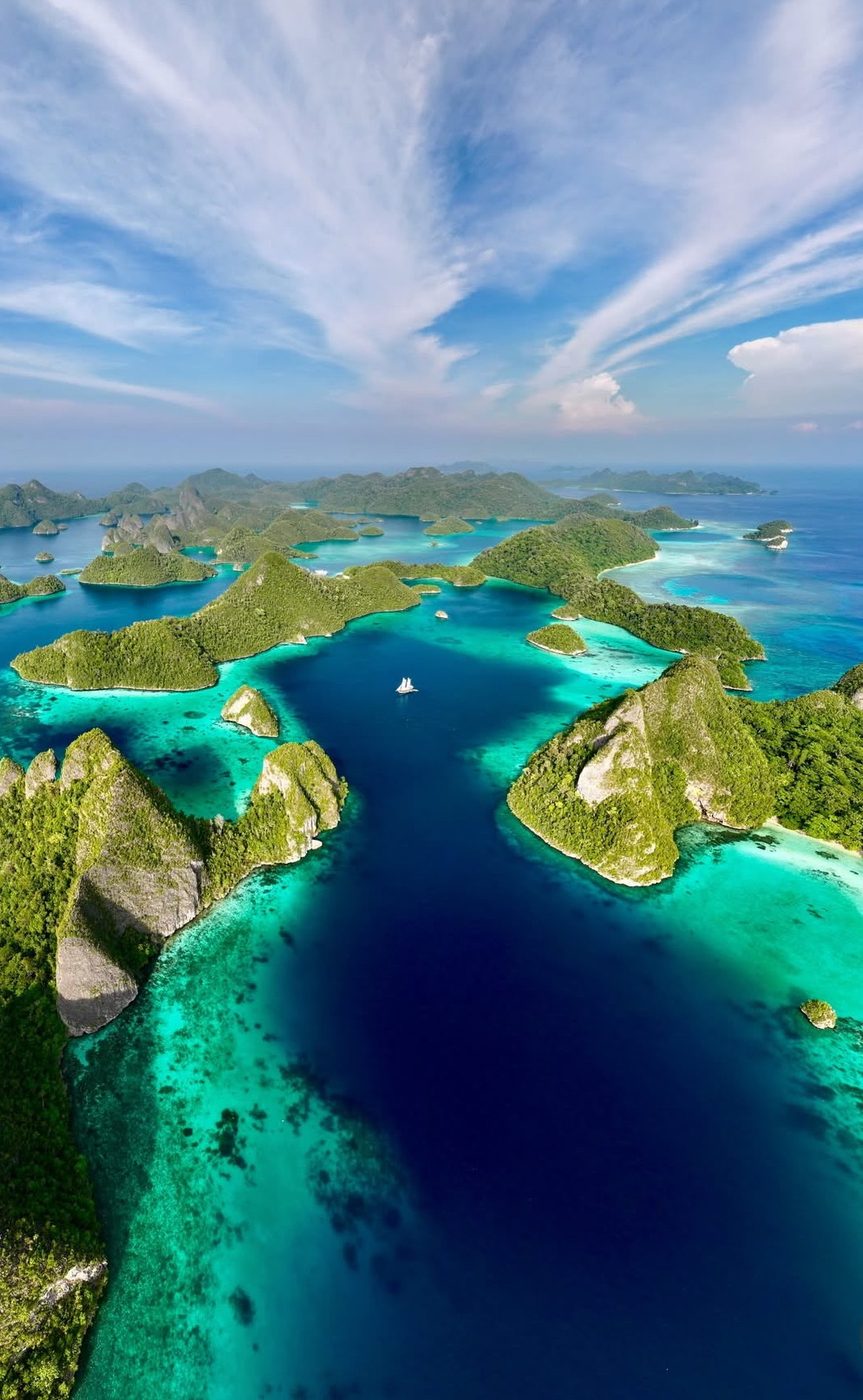 Aerial view of forested karst islands and turquoise lagoons in Raja Ampat