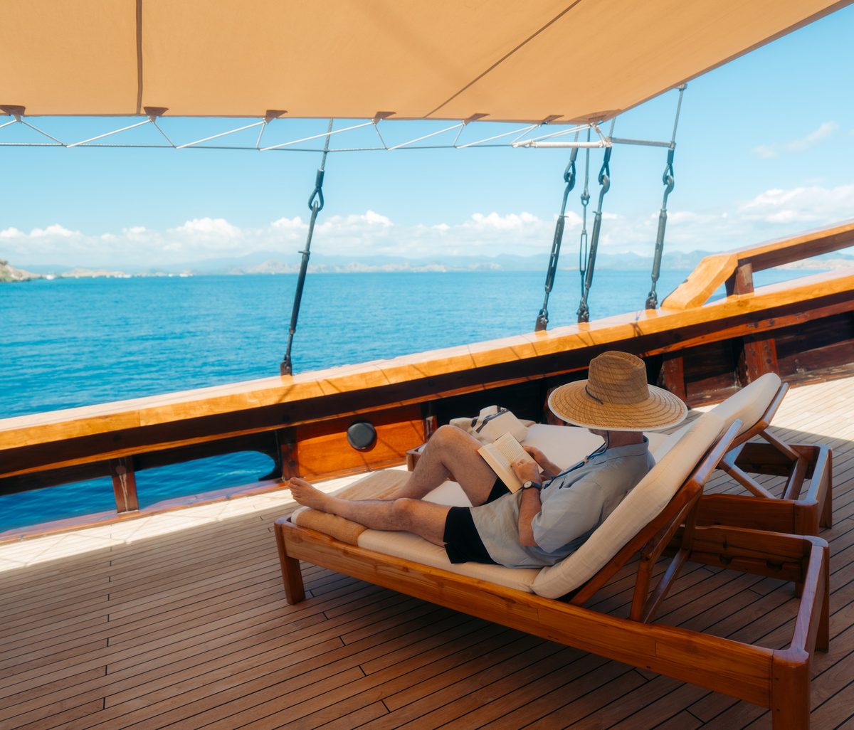A guest reading on a daybed under a canopy