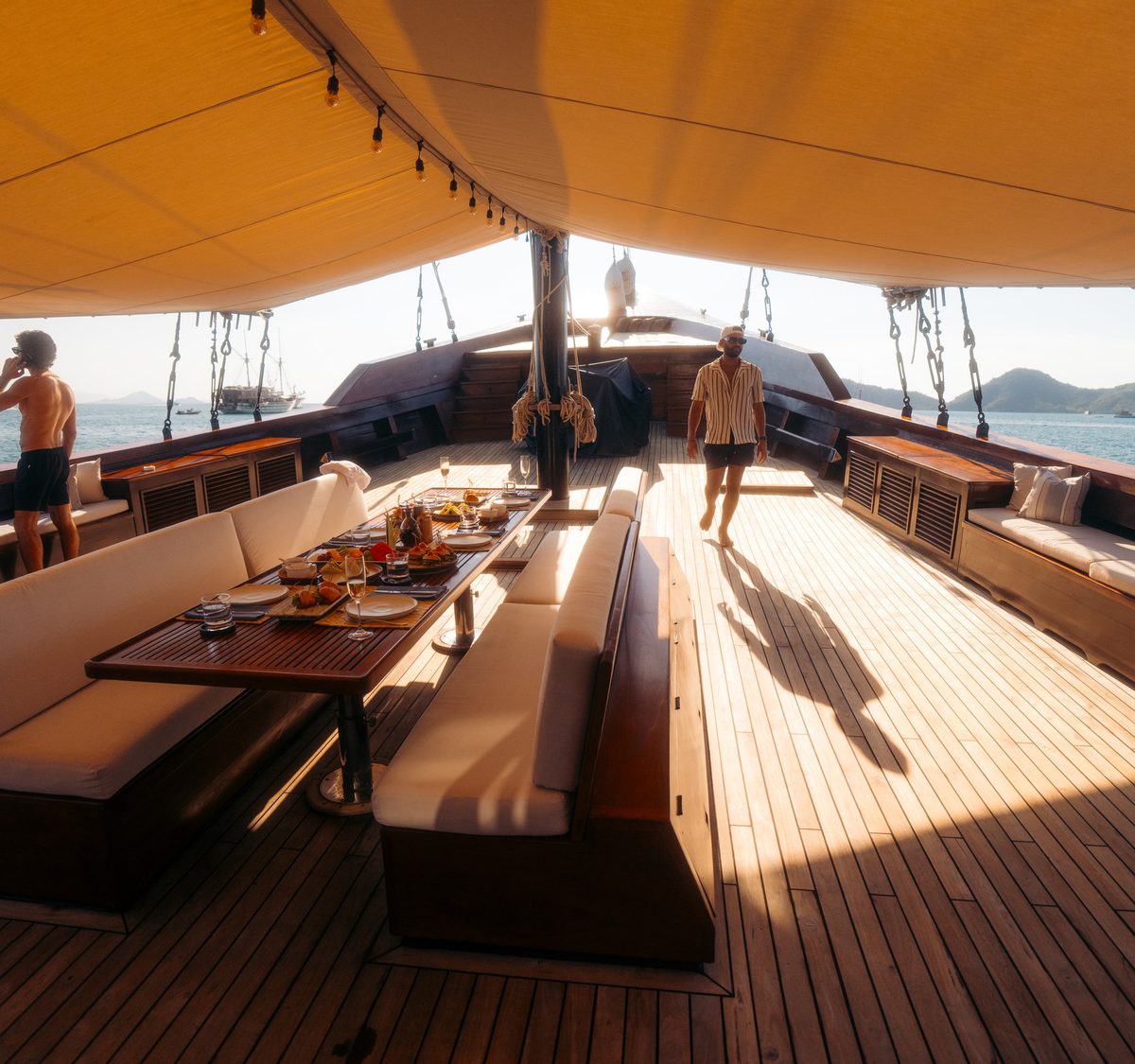 A long table laid for dinner on an open deck