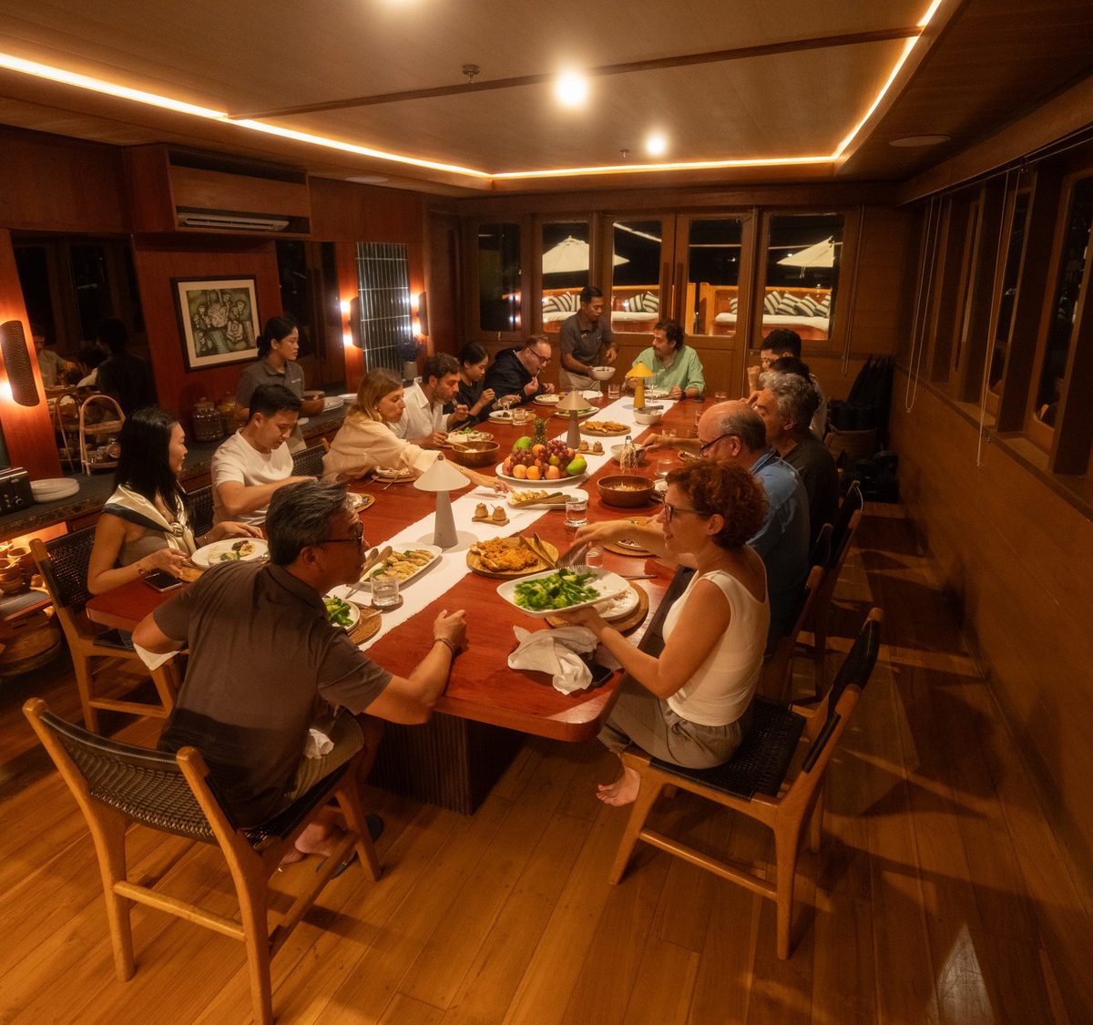 Guests dining together in a warm-lit saloon