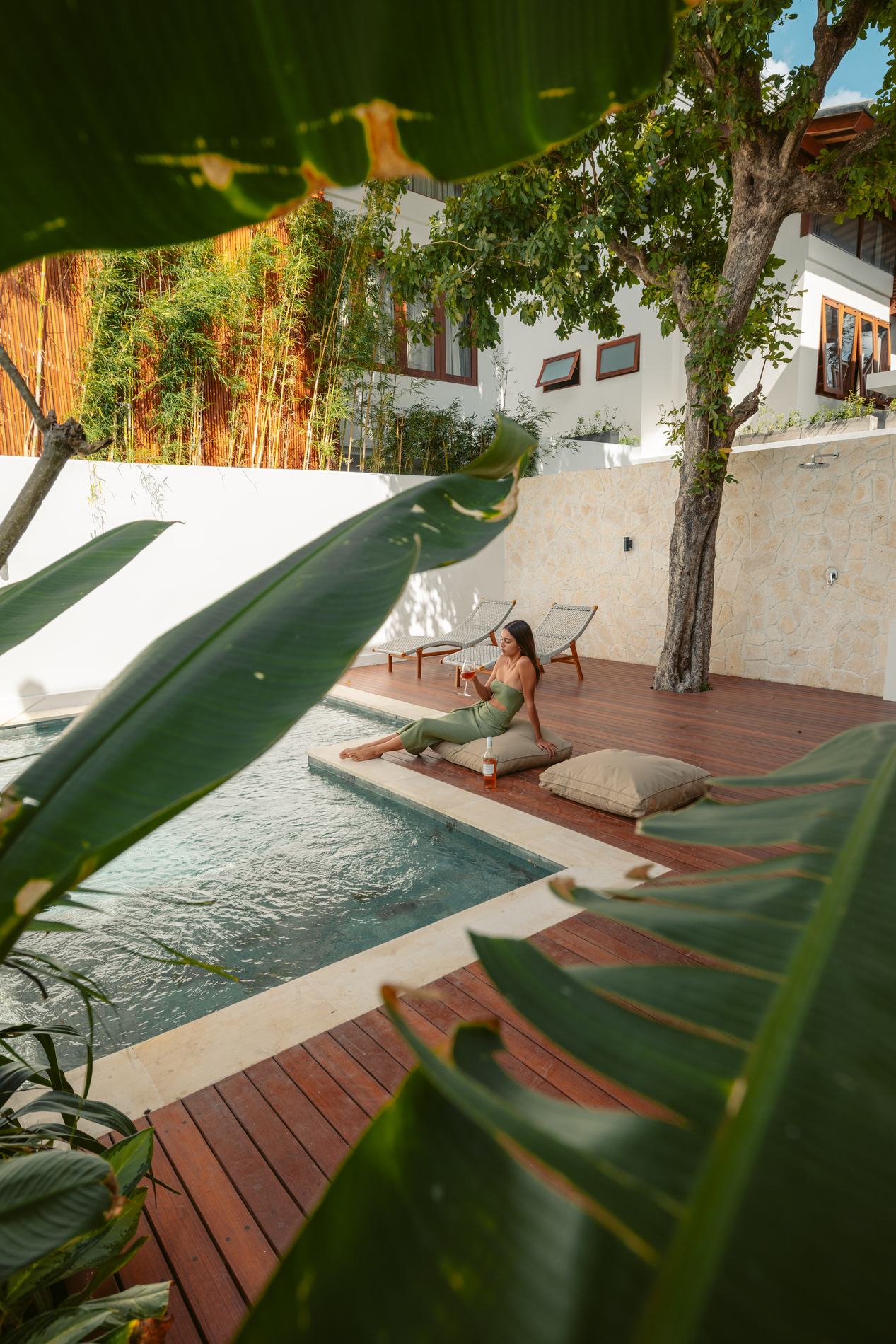 The pool and deck seen through leaves