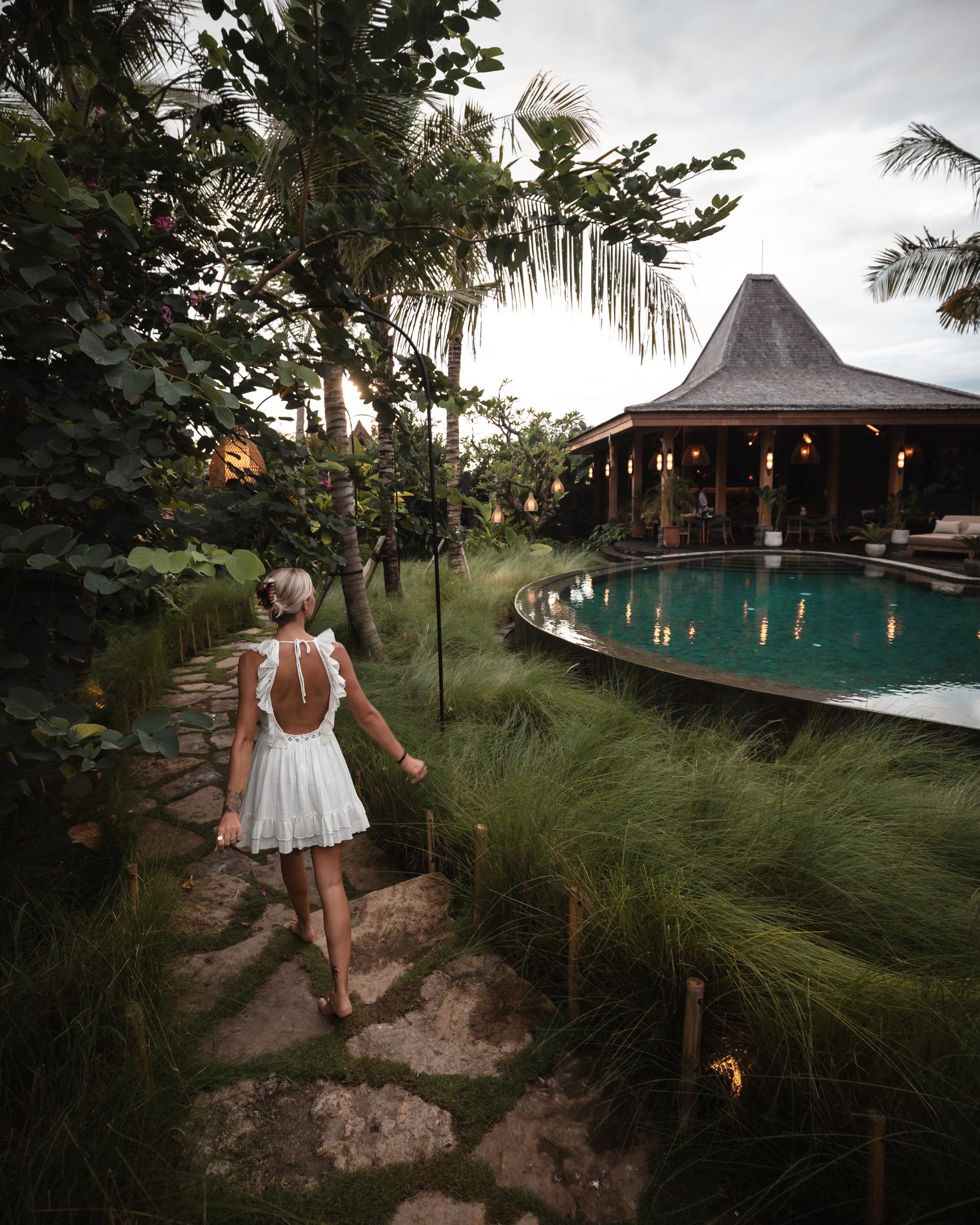 A woman walking down a stone path toward the pavilion