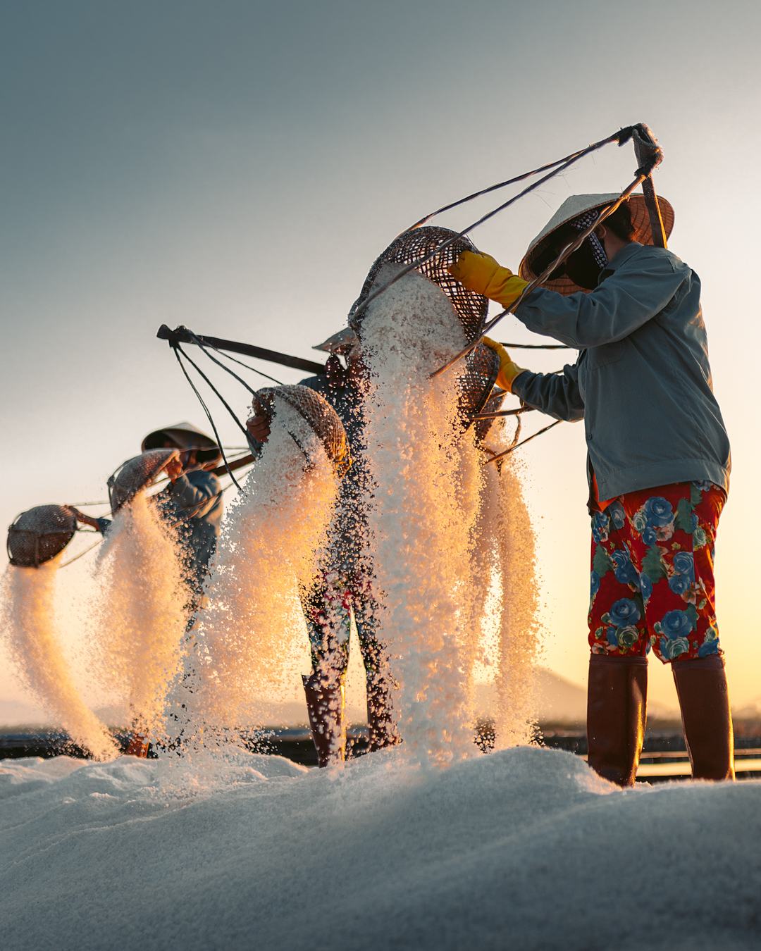 A worker tipping salt from baskets into the light