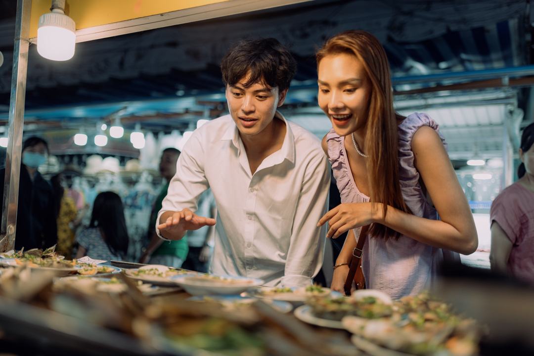 A couple choosing seafood at a night market stall