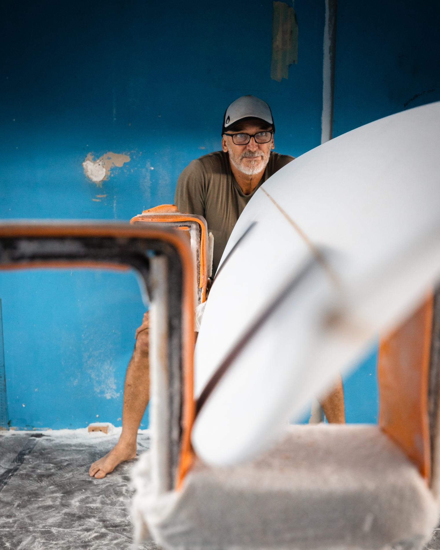 The shaper looking through the frame of a board stand