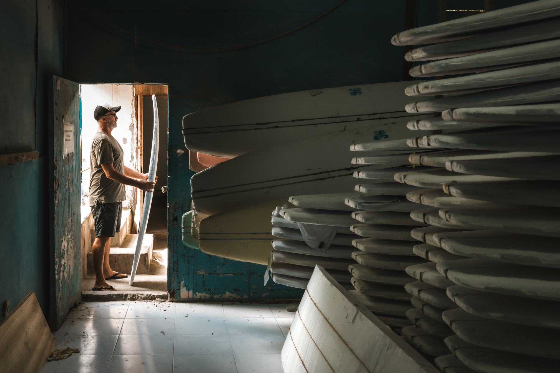 The shaper in the doorway with racks of boards stacked beside him